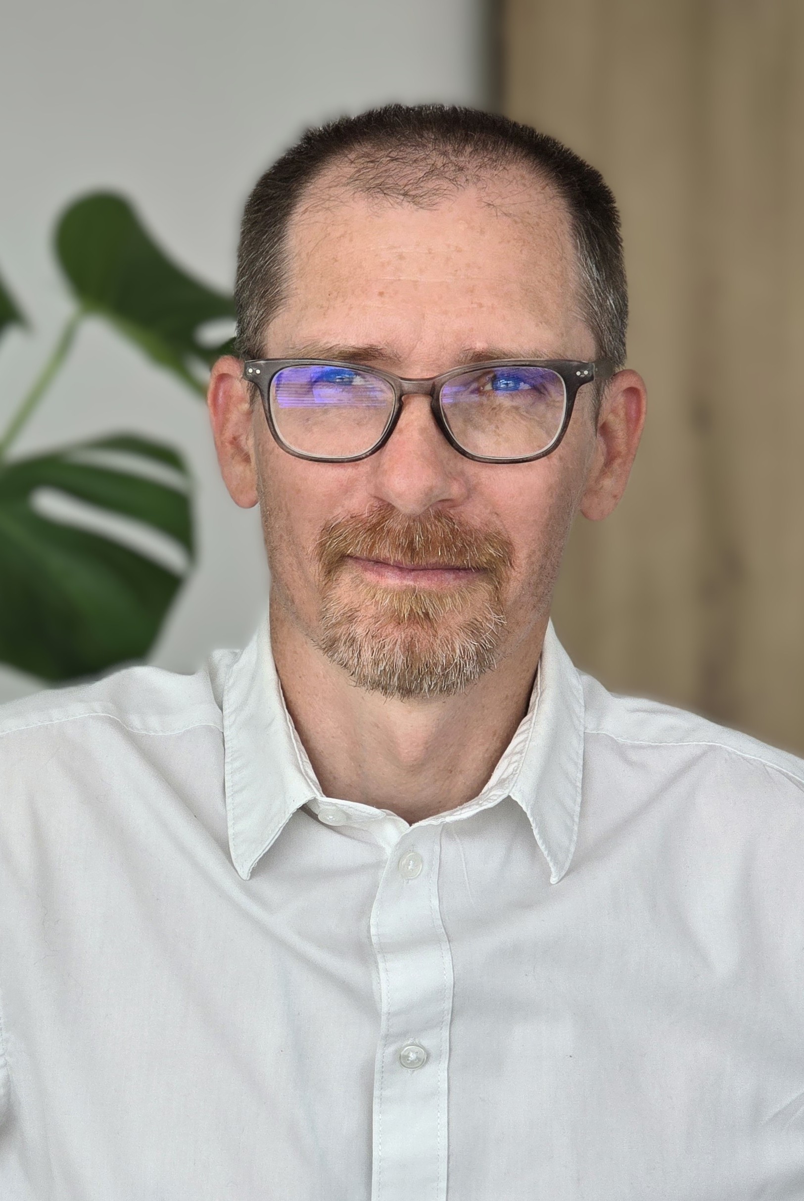 Zdjęcie portretowe mężczyzny w białej koszuli i okularach